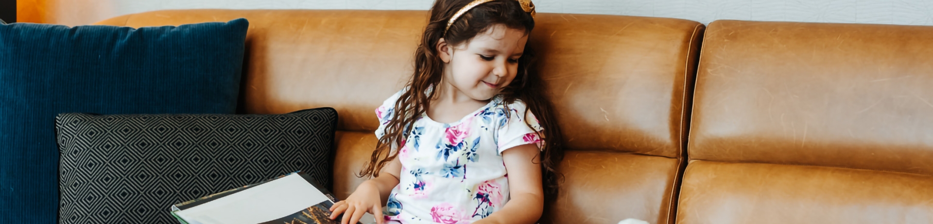 a little girl reading a book and staring at a stuffed bunny