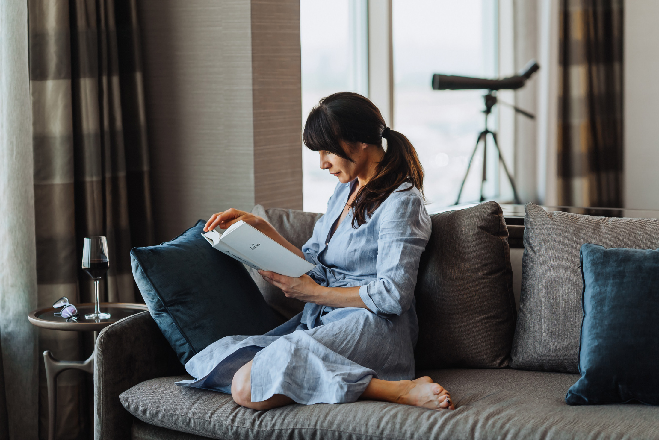 a woman sitting on the couch reading