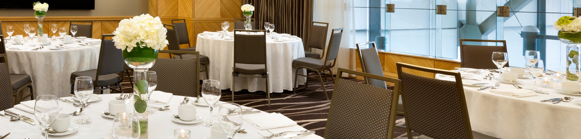 meeting room with glass windows and round tables set up for a reception
