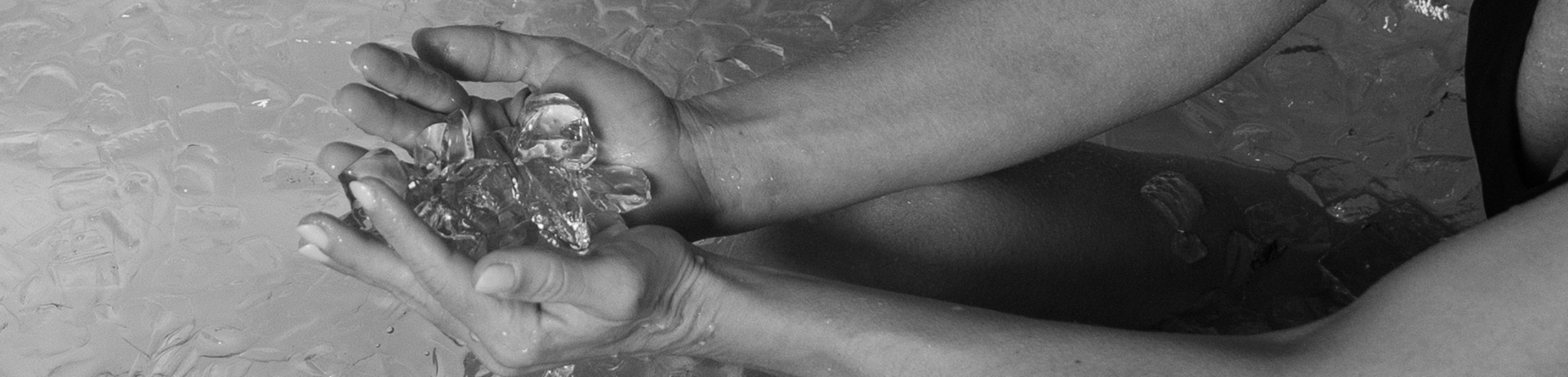 black and white photo of a woman in an ice bath holding ice