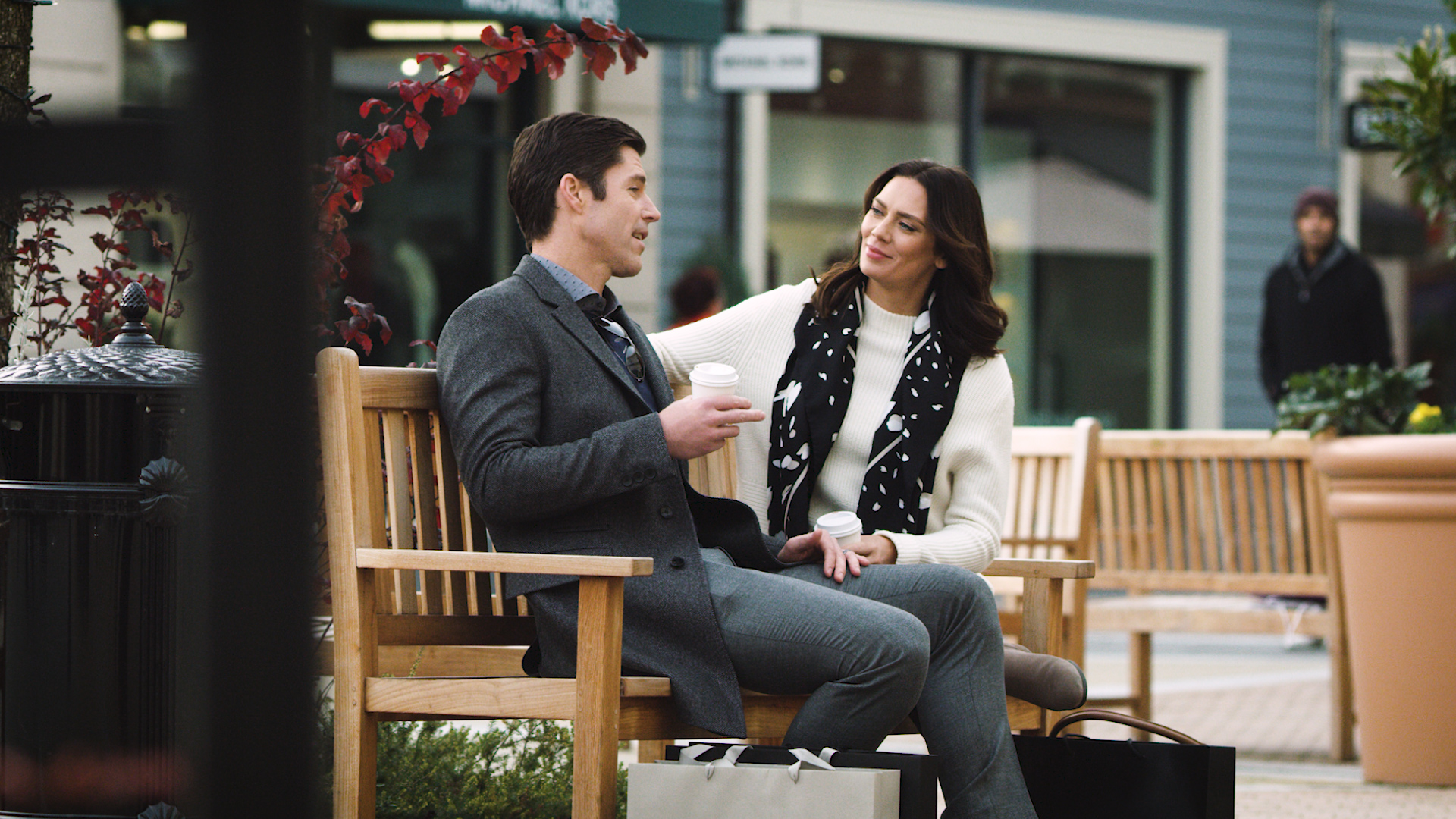 couple drinking coffee on a park bench