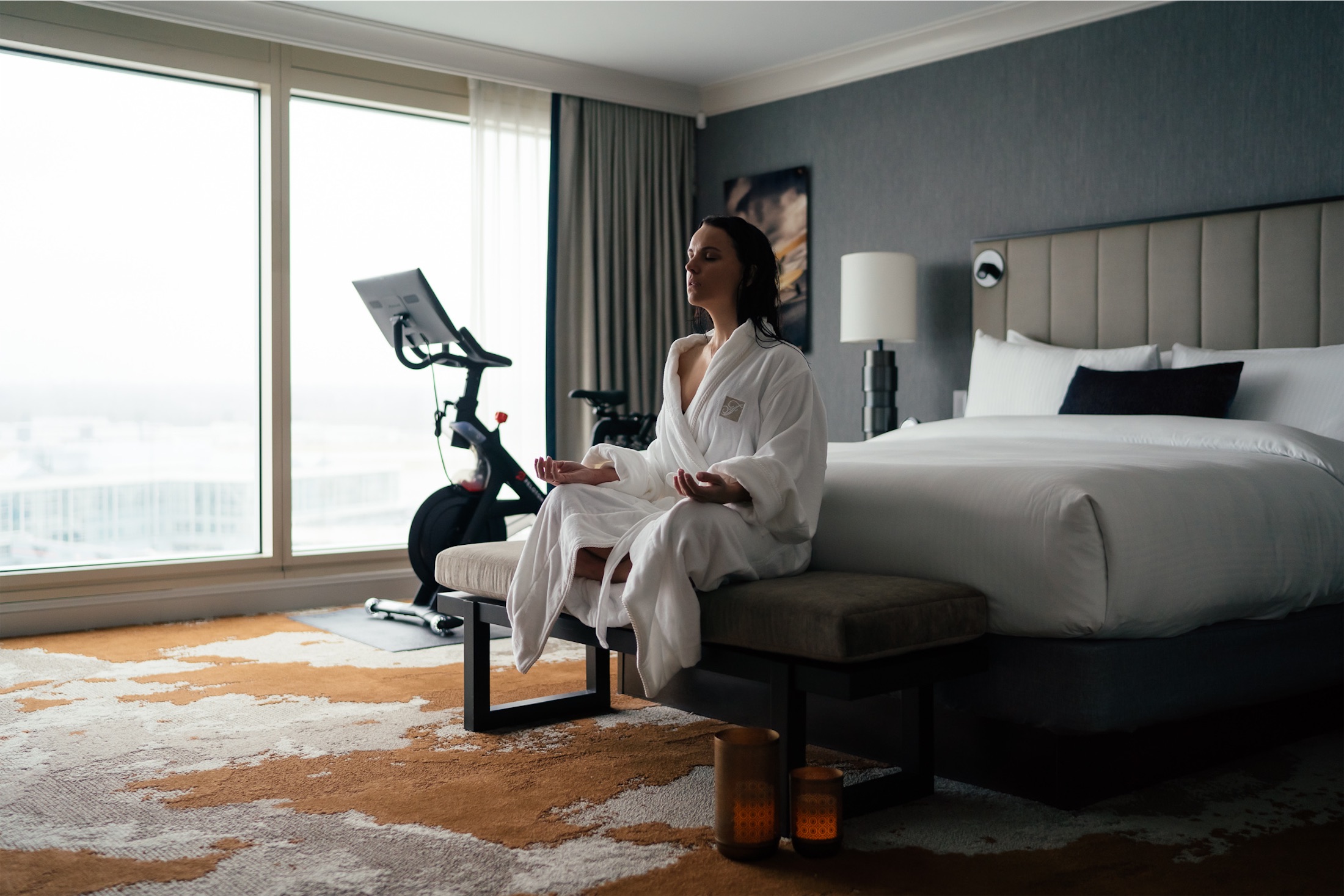 woman meditating on a bench in front of her bed