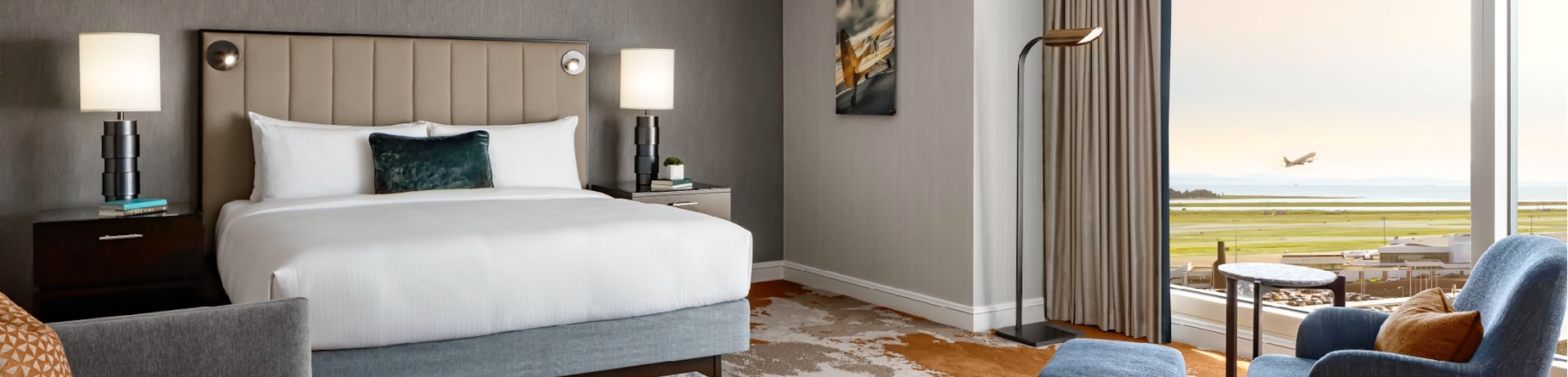 bedroom with seating area a view of a plane taking off