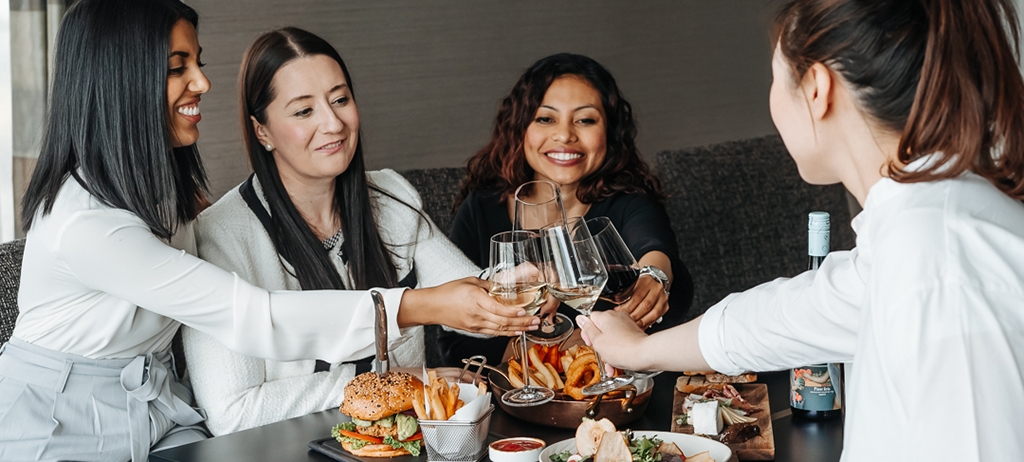 group of friends clinking wine glasses together