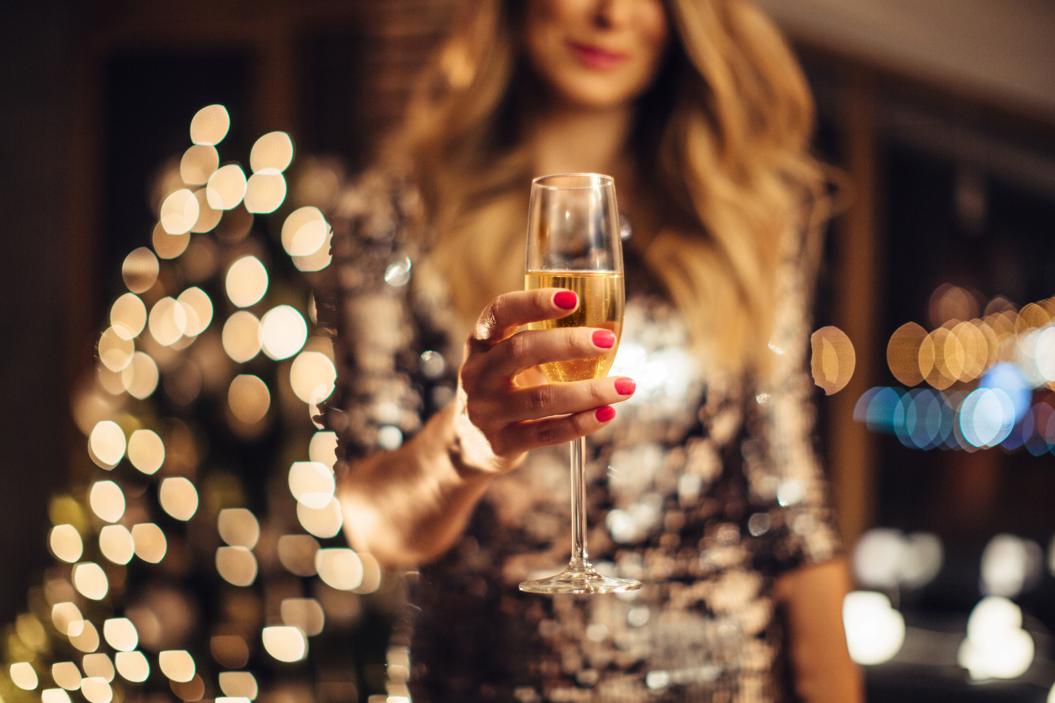 Woman in a gold dress toasting with Champagne