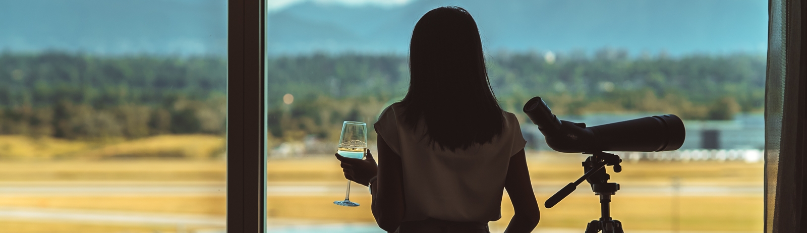 Woman enjoying the view with a telescope and a glass of wine