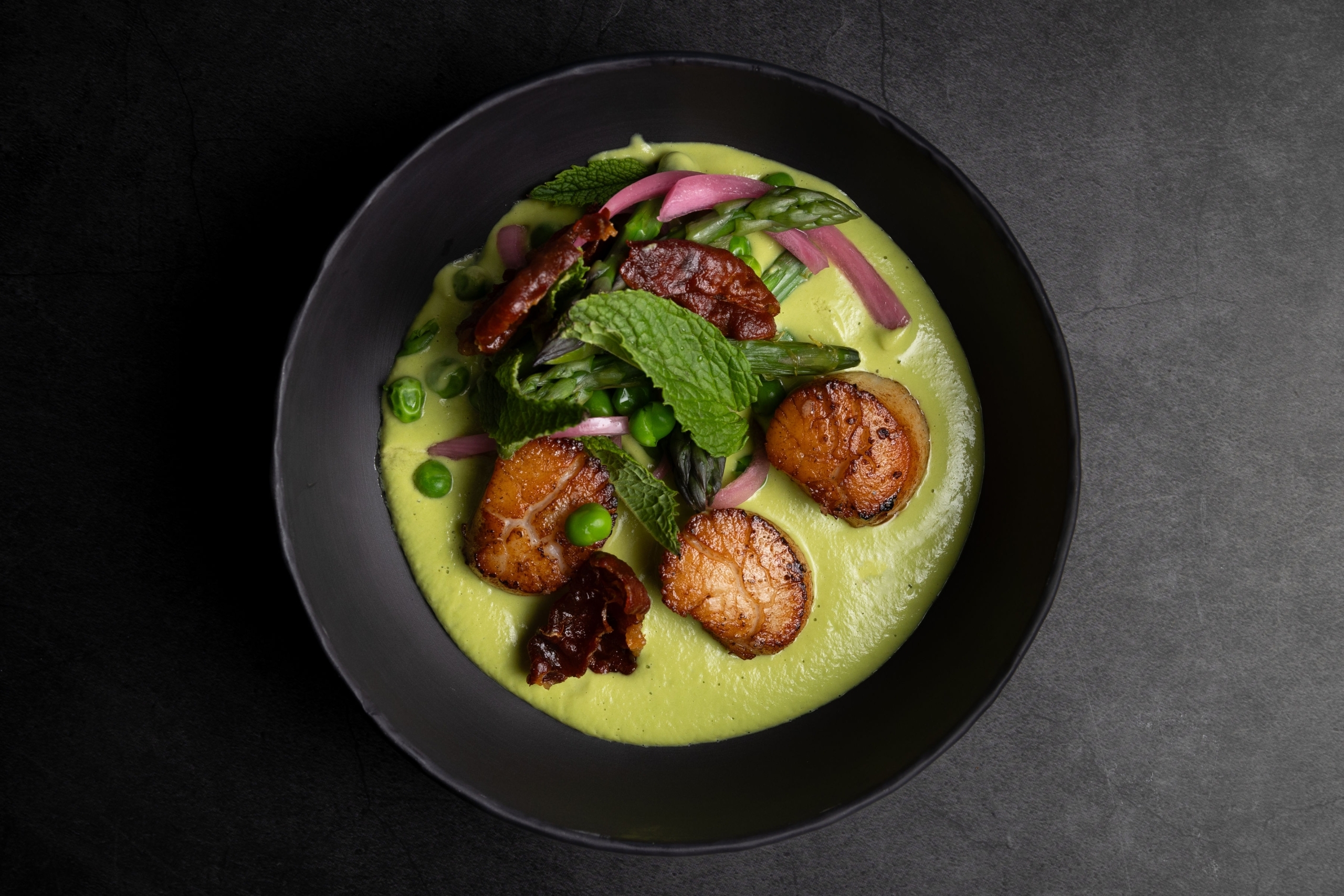 Seared scallops in a bright green pea puree