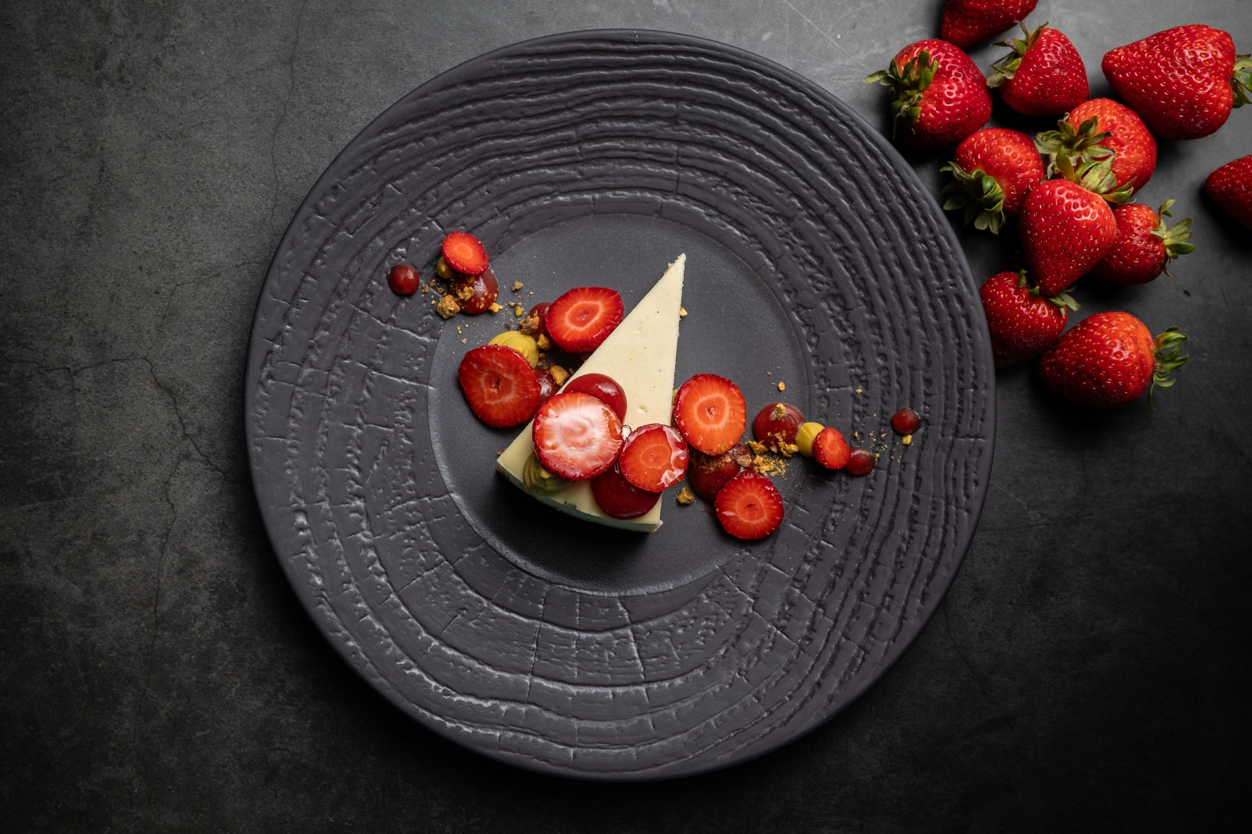 A plate of cheesecake with strawberries