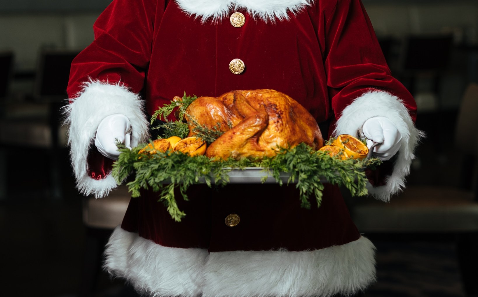 Santa holding a tray of turkey