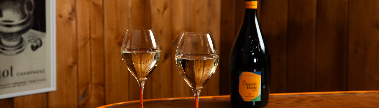 Two glasses of Veuve Clicquot Champagne with a chalet-style background