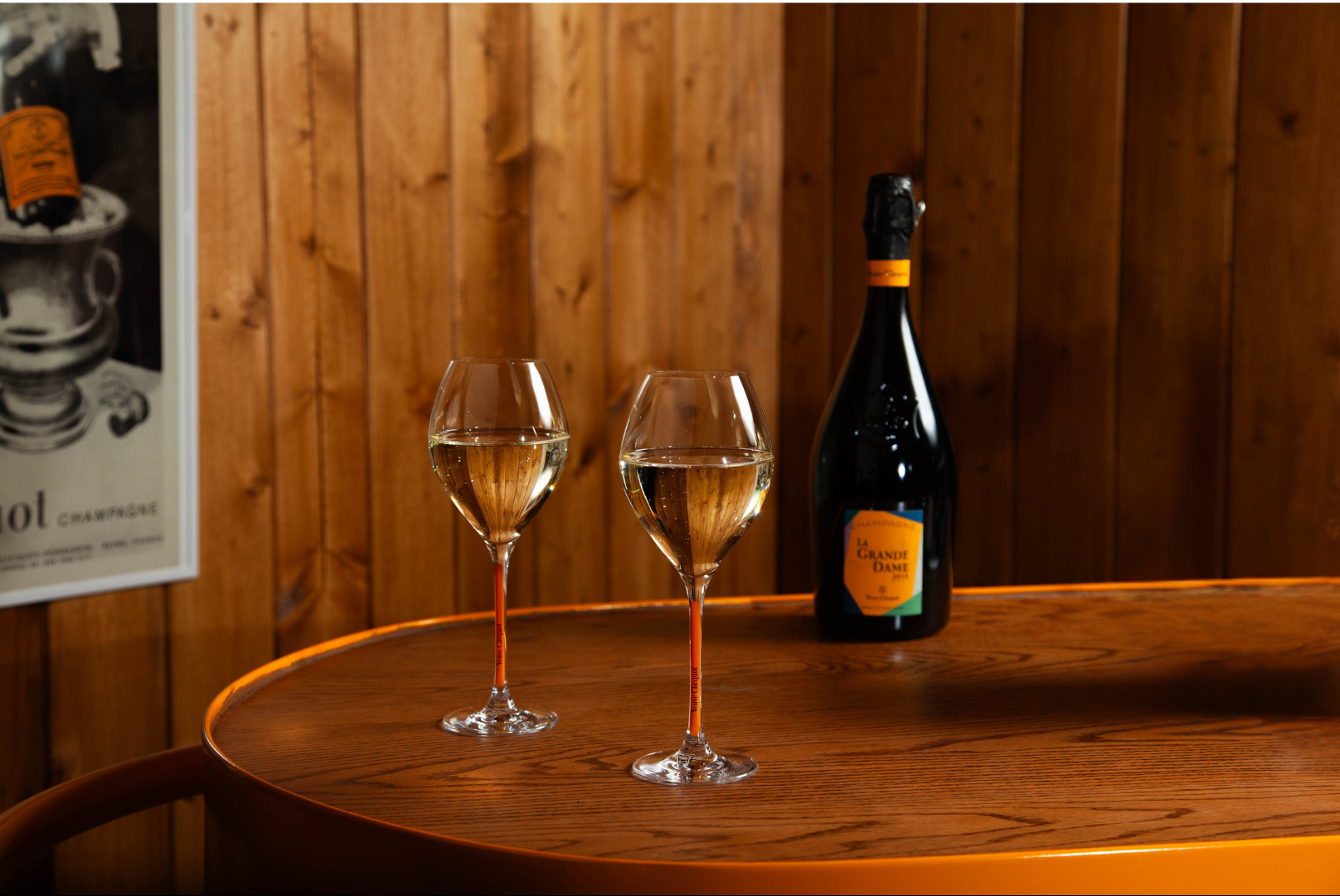 Two glasses of Veuve Clicquot Champagne with a chalet-style background